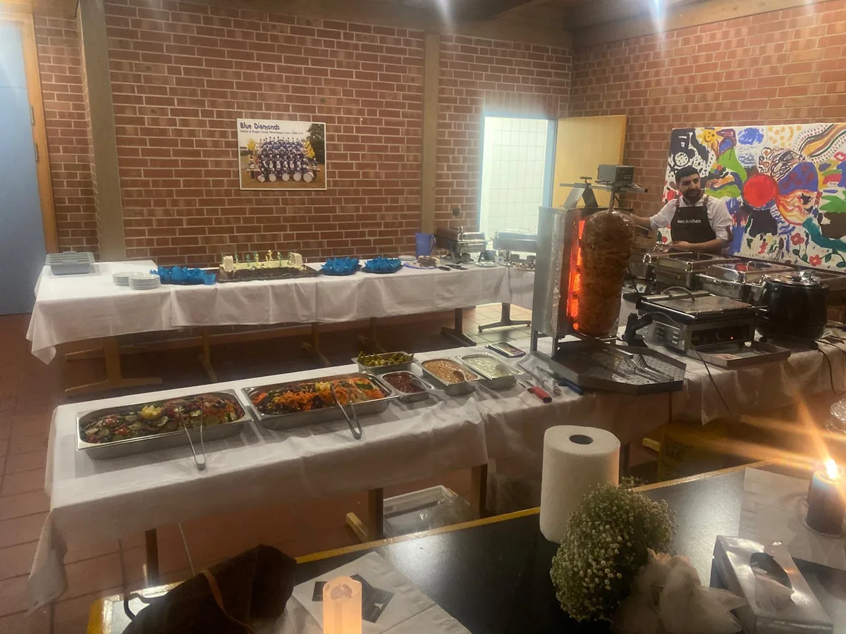 Mendos Partyservice: Buffet mit Salaten und Drehspieß in einer Festhalle